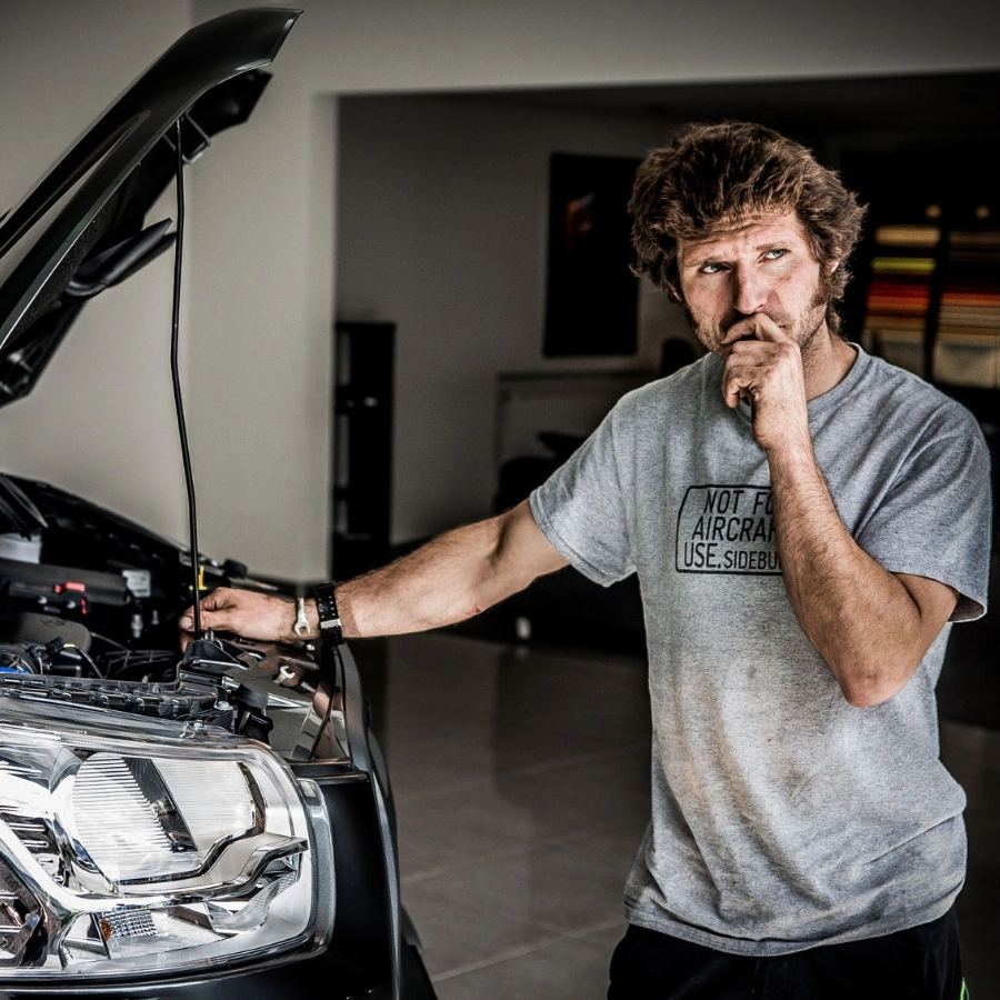 Guy Martin standing in thought about the design of his Proper Ford Transit with hood up