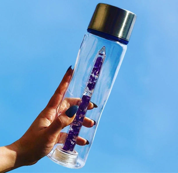 Bewater water bottle held in the sky with purple gemstones