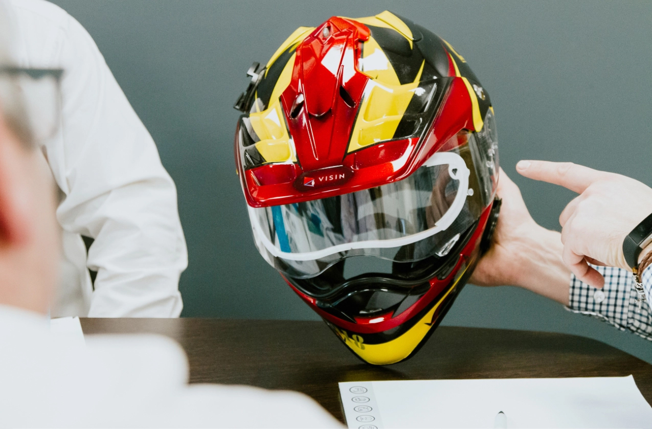 Motorcycle helmet in black, yellow and red showing demisting visor that was developed