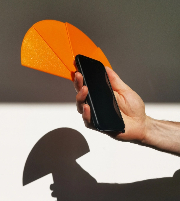 Shady phone sun blocker product in orange with shadows