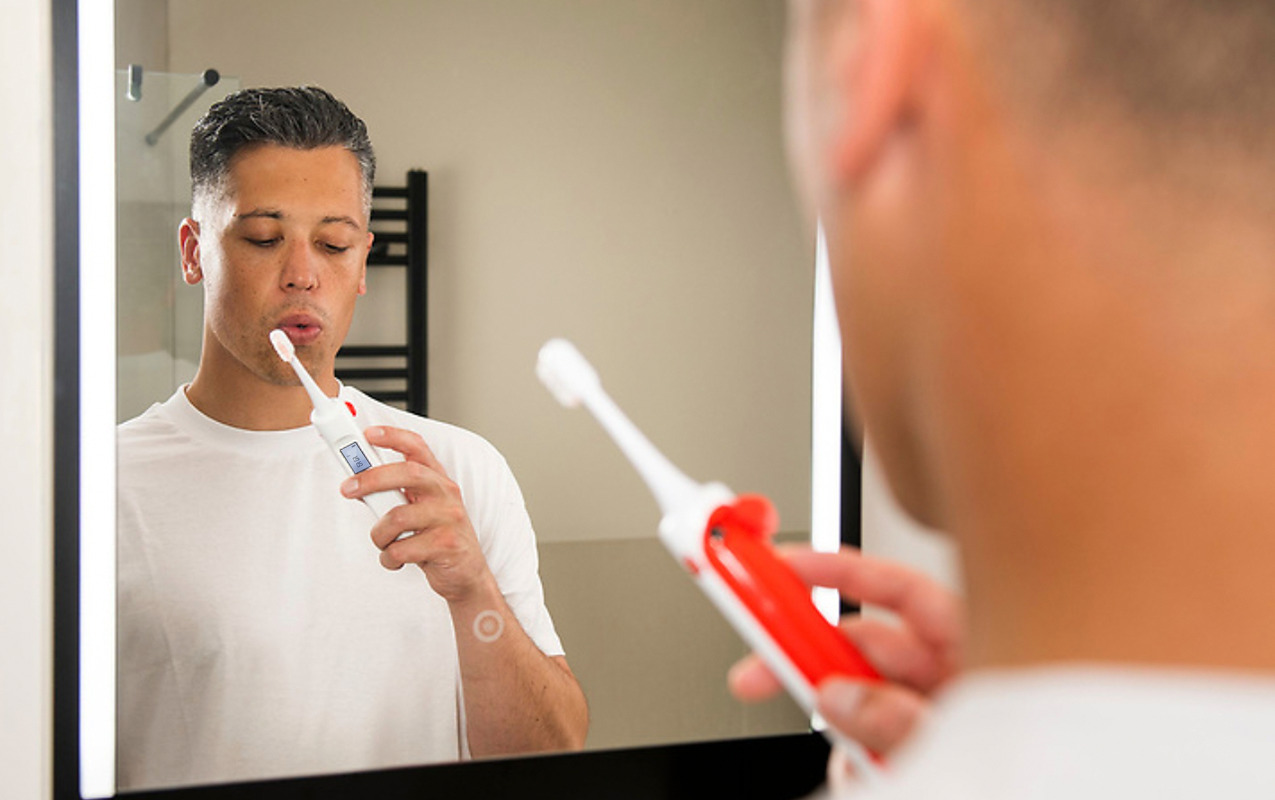 Person using the toothbrush breathalyser invention designed by Simple Design Works for Direct Line