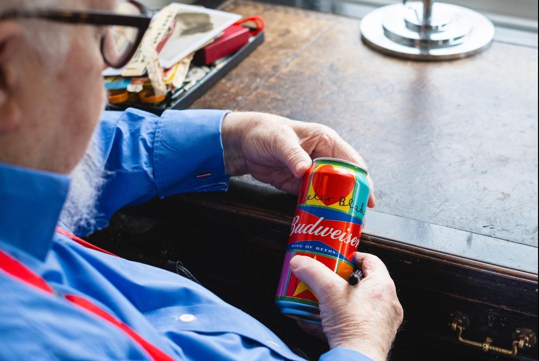 Sir Peter Blake studies a branded can of Budweiser. Image courtesy of www.budweiser.co.uk